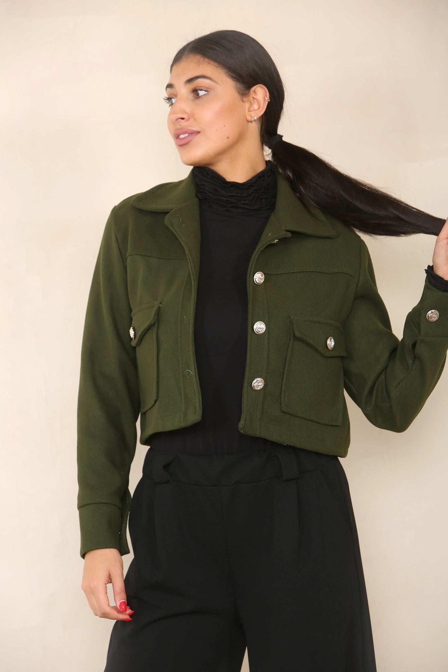 model wears a khaki crop collar jacket in leightweight material.  The jacket is buttoned up style withfront flap pockets.  Button detail on the cuffs.  Selling at wholesale for fashion boutiques looking for a wider range of new stock